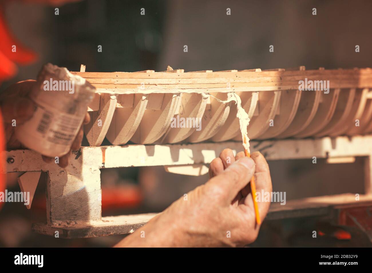 Vieil homme travaillant sur la création d'une maquette en bois d'un bateau Banque D'Images