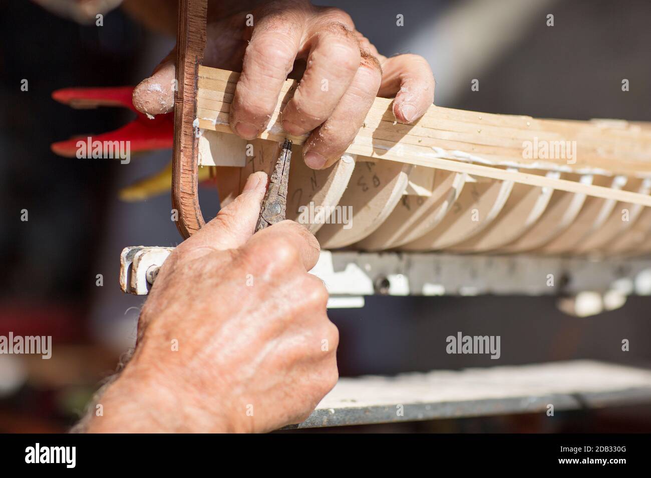 Vieil homme travaillant sur la création d'une maquette en bois d'un bateau Banque D'Images