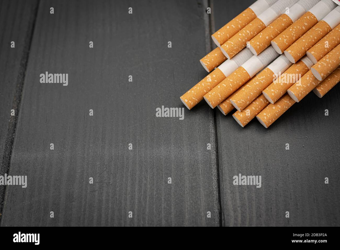 Jeu de filtres à cigarettes de tabac alignés dans le coin supérieur droit sur un bois gris Banque D'Images