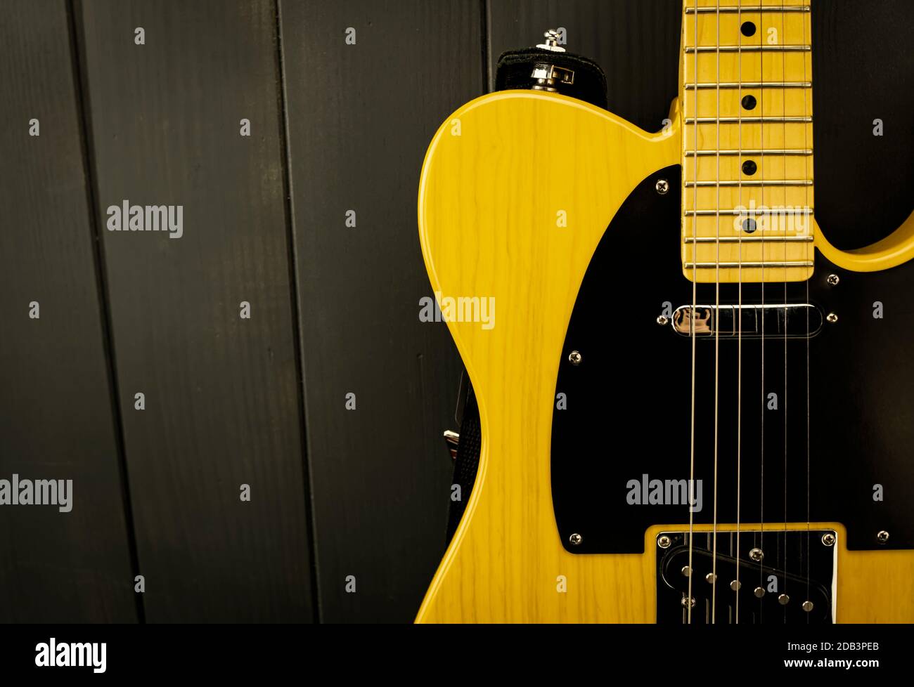 Détails d'une guitare électrique classique en jaune et noir, avec ses frettes, cordes, cou et microphone Banque D'Images