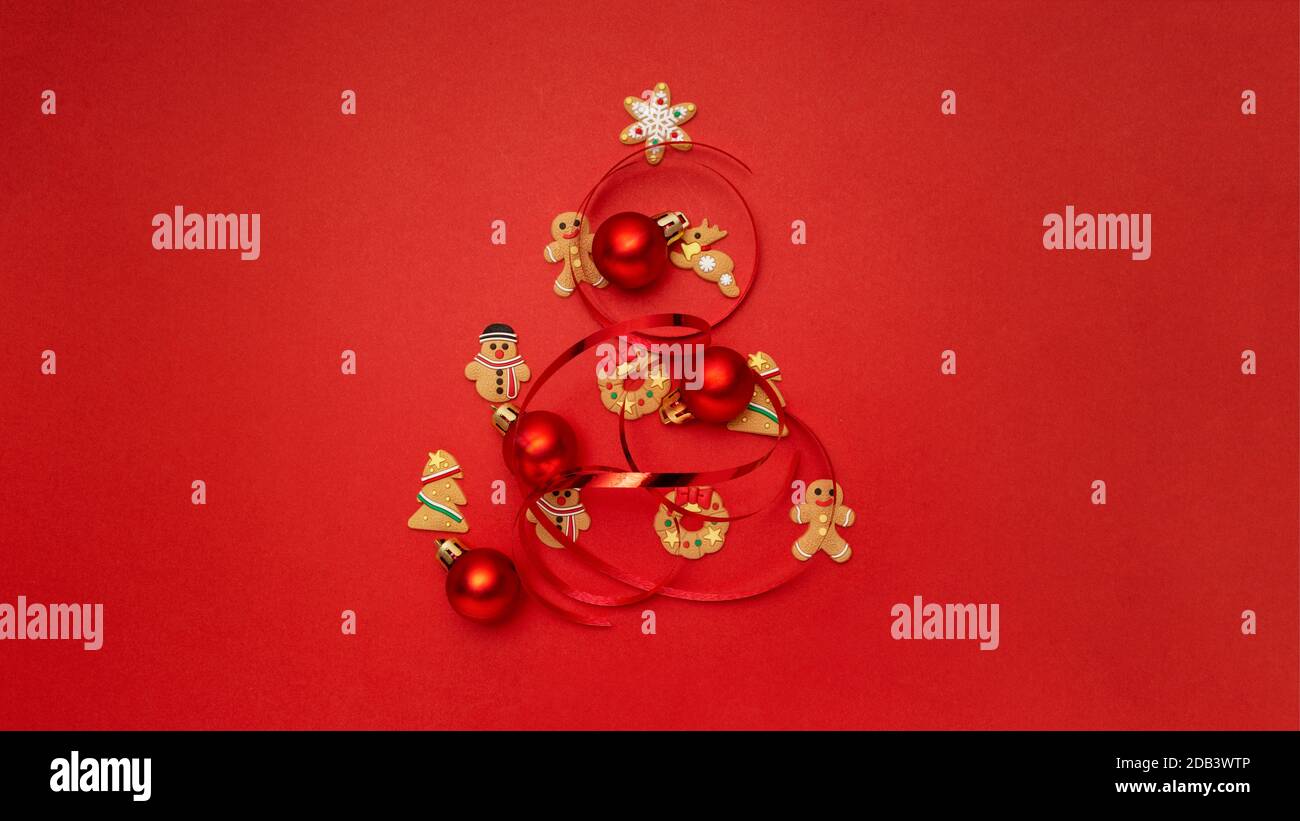 Arbre de Noël fait avec des biscuits de Noël et des boules de Noël arrière-plan rouge Banque D'Images