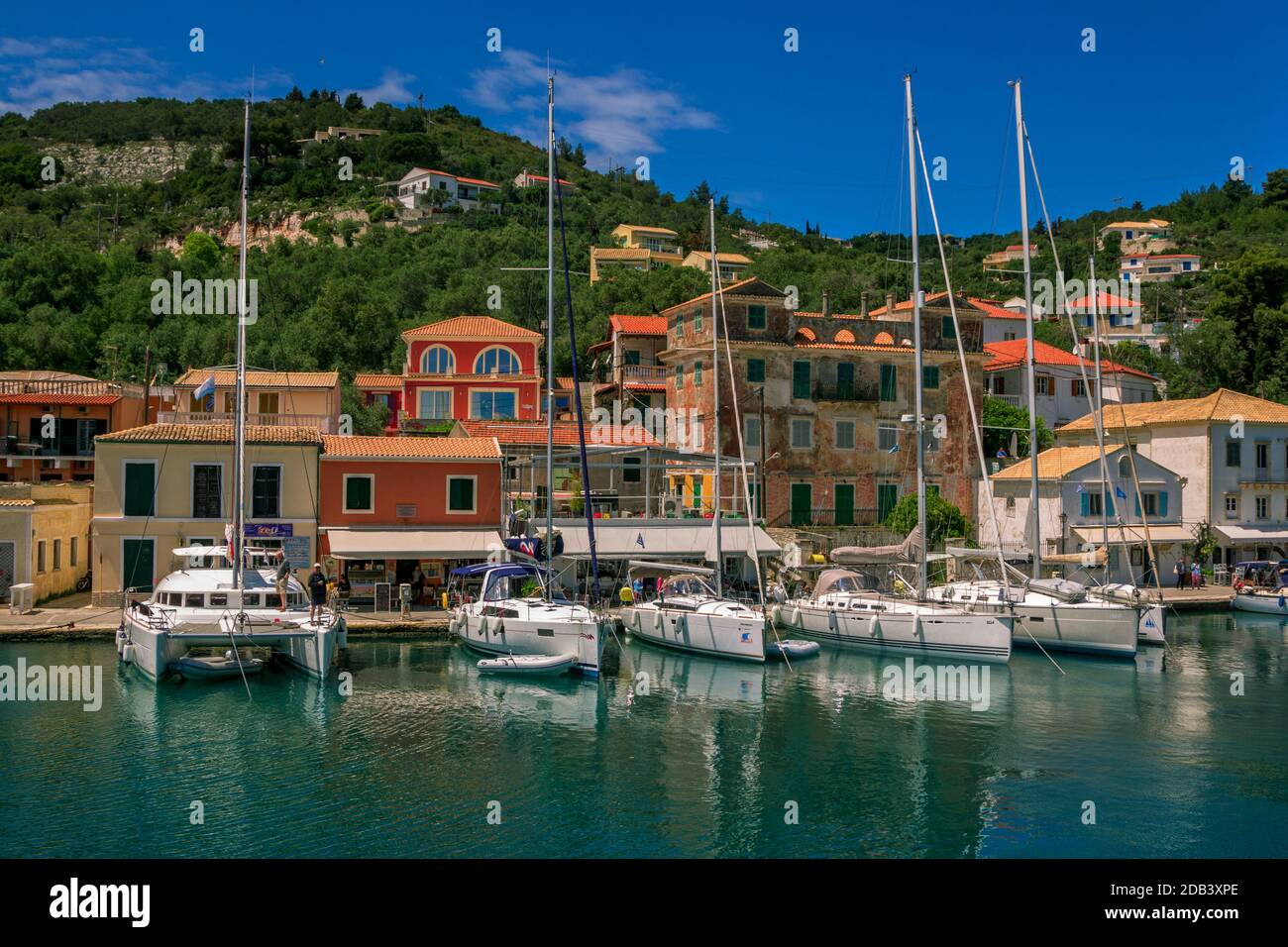 Ile de Paxos/Grèce- 7 mai 2019: Vue sur le magnifique port de Loggos - baie de mer avec l'eau turquoise calme, les navires et les yachts coloré vieilles maisons et bleu s Banque D'Images