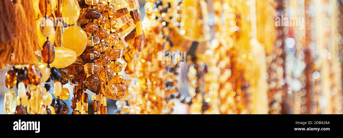 Perles ambrées dans une fenêtre de magasin de bijoux. Bijoux design. Fond orange des perles Banque D'Images