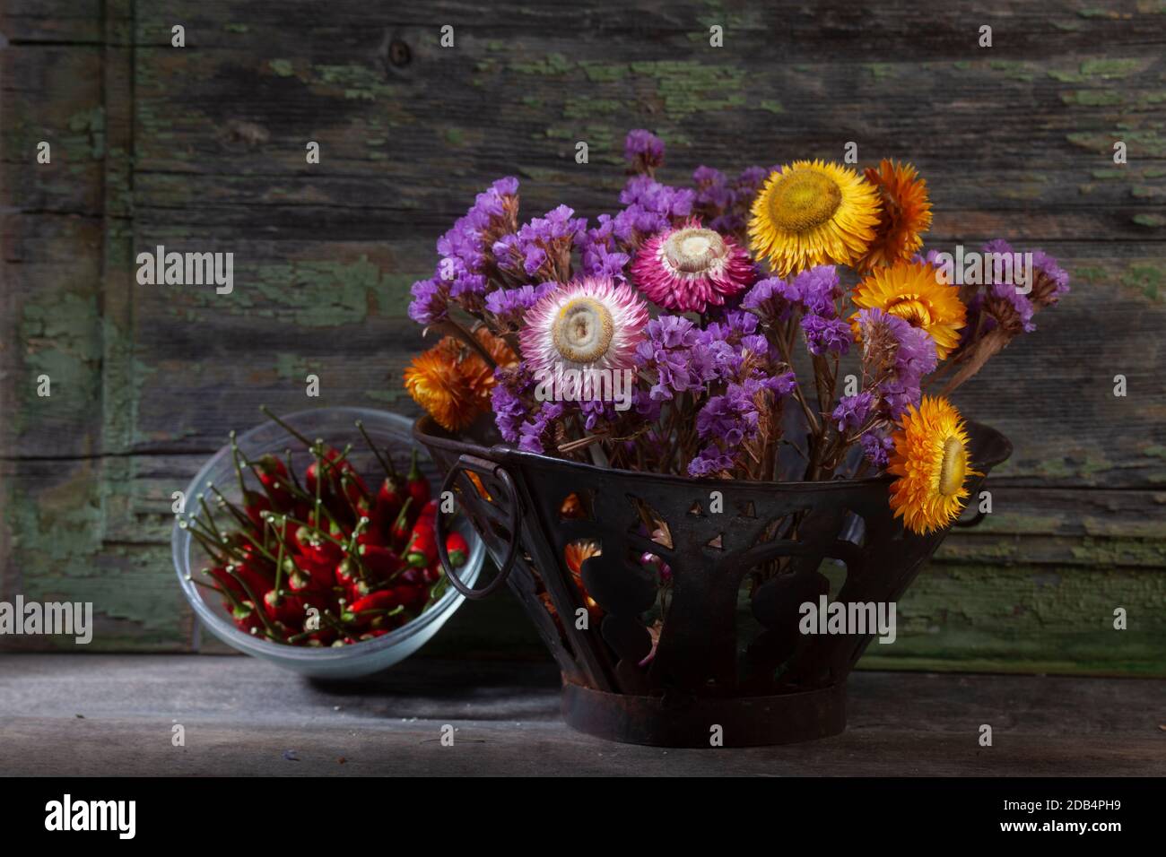 STILL Life gros plan photo du bouquet de vif séché Fleurs et poivrons sur fond en bois Banque D'Images