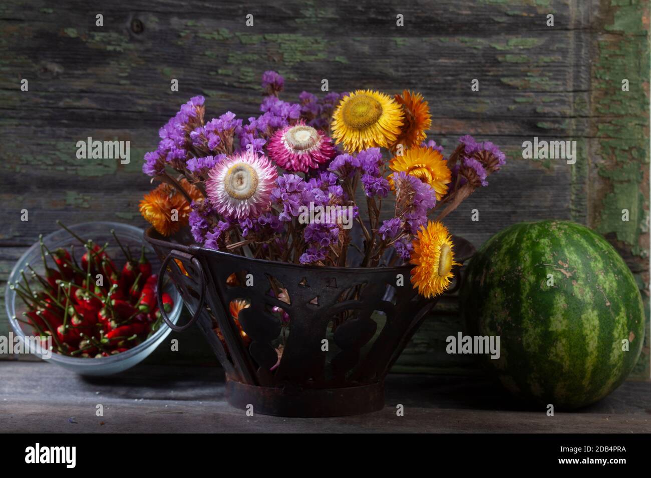 STILL Life gros plan photo du bouquet de vif séché Fleurs et poivrons avec pastèque sur fond de bois Banque D'Images