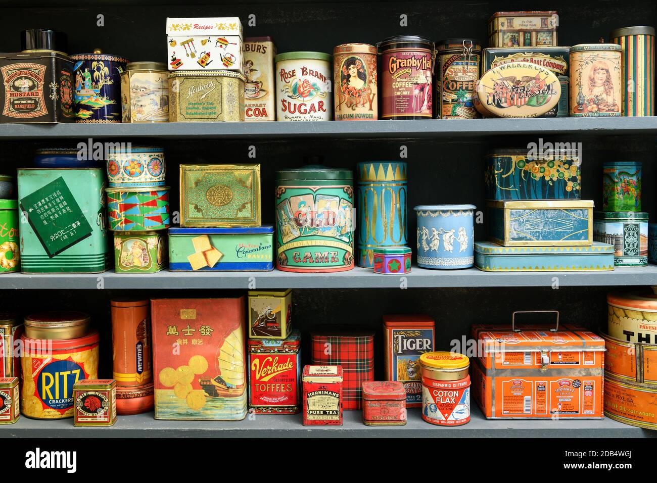 Grande collection de boîtes vintage colorées sur une étagère utilisée comme emballage de détail avec publicité de marque et disposées selon la couleur Banque D'Images