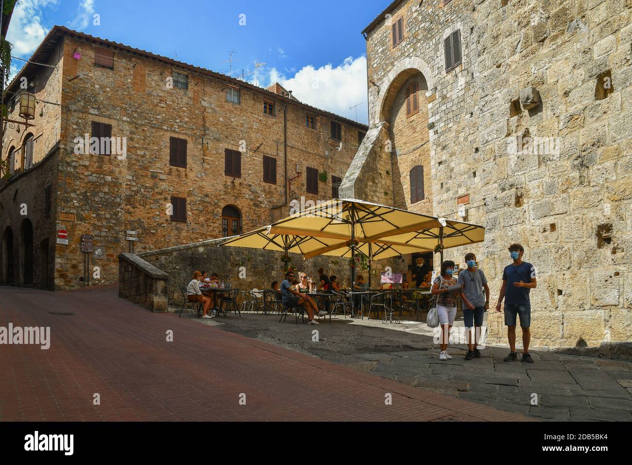 Aperçu du village médiéval de San Gimignano, site classé au patrimoine mondial de l'UNESCO, avec des gens et des touristes dans un café en plein air, Sienne, Toscane, Italie Banque D'Images
