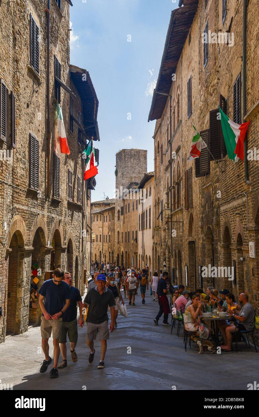 Vue sur l'allée principale de la via San Giovanni de la ville médiévale de San Gimignano, site classé au patrimoine mondial de l'UNESCO, surpeuplée de touristes, Sienne, Toscane, Italie Banque D'Images