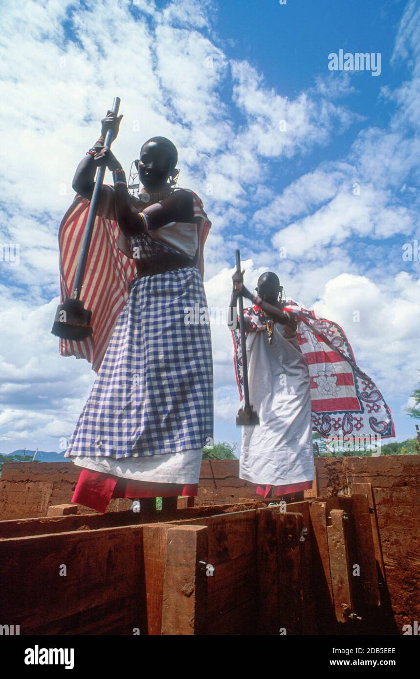 Les femmes Maasai construisent une maison de terre rammée, Kajiado, Kenya Banque D'Images