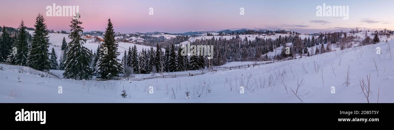 Petit village alpin calme et lever de soleil d'hiver montagne enneigée autour, Voronenko, Carpates, Ukraine. Banque D'Images