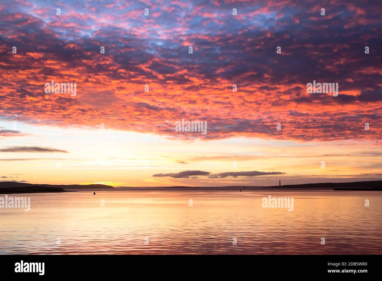 Nuages multicolores au-dessus de la mer du Nord calme dans la ville d'Orkney pendant lever du soleil Banque D'Images