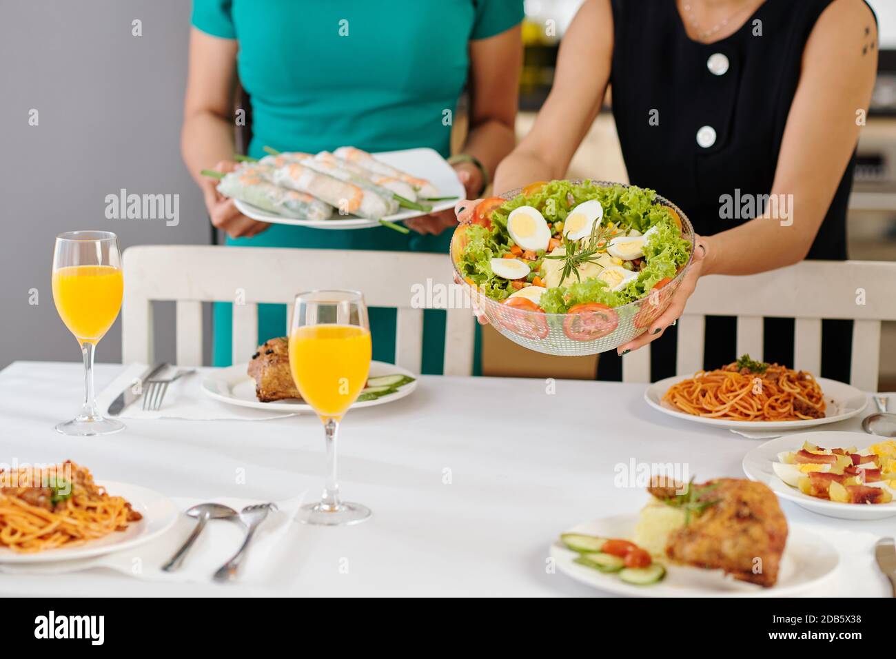 Mettre la nourriture sur la table du dîner Banque D'Images