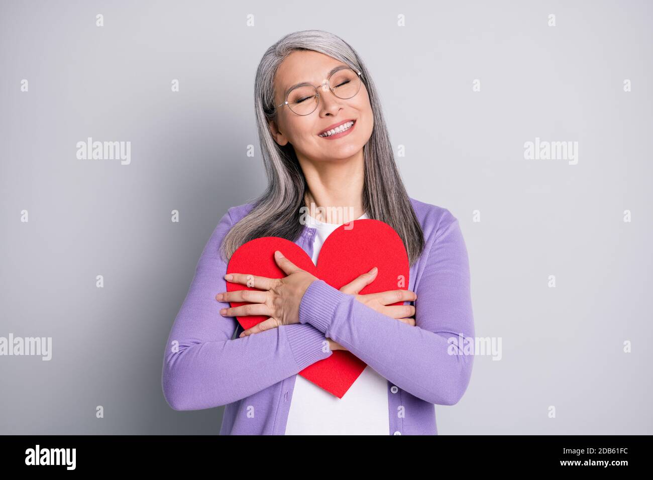 Photo Portrait De La Granny Embrassant Grand Papier Rouge Carte De Coeur Porter Une Chemise Violette Isolee Sur Fond Gris Photo Stock Alamy