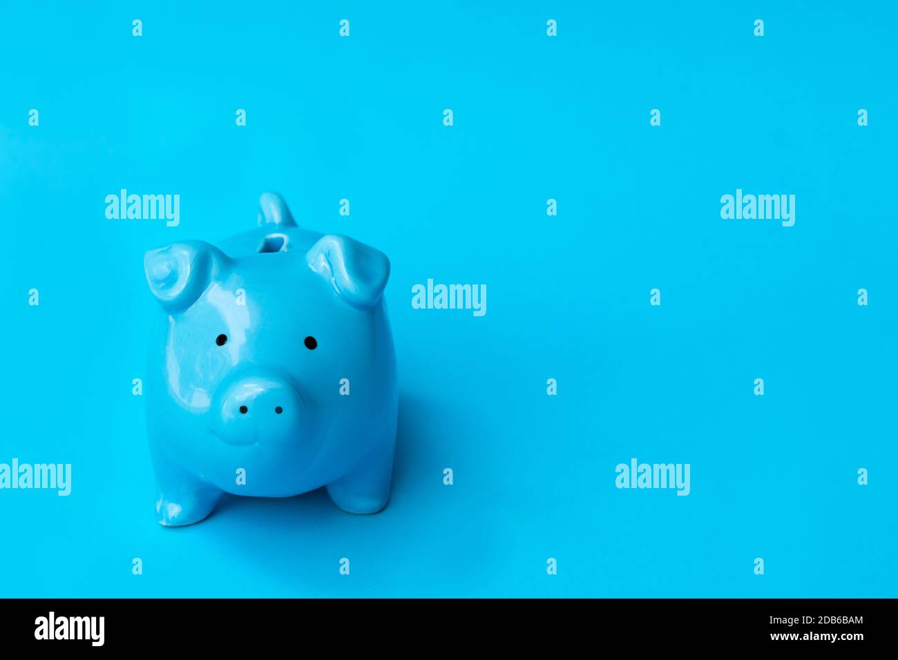 Le sourire de la banque de porc bleue est isolé sur fond bleu. Finance, économie d'argent concept. Banque D'Images