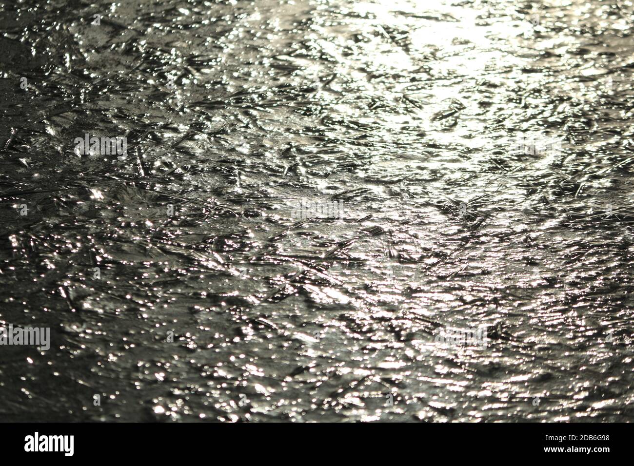 Surface du lac gelée au soleil. Fond de glace texturé. Arrière-plan abstrait glacé. Banque D'Images