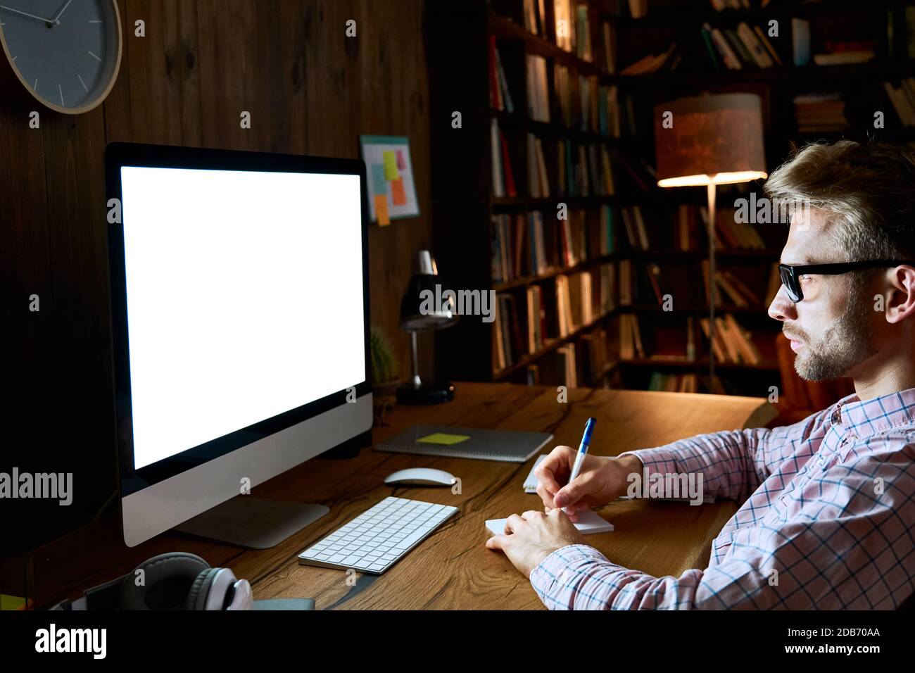 Homme d'affaires sérieux utilisant un ordinateur regardant le moniteur d'écran blanc maquette. Banque D'Images