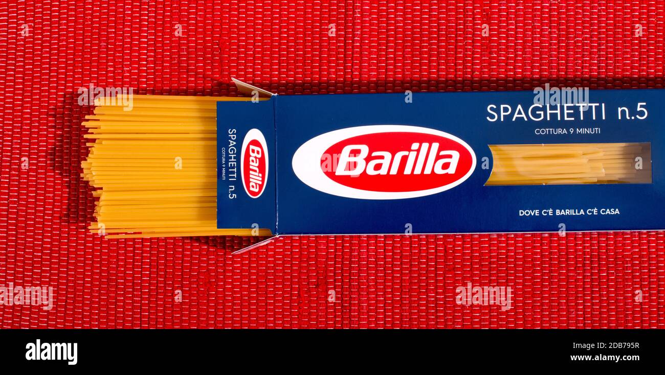 Paquet ouvert de pâtes à base de spaghetti à la Barilla dans l'emballage de détail vu sur fond textile rouge Banque D'Images
