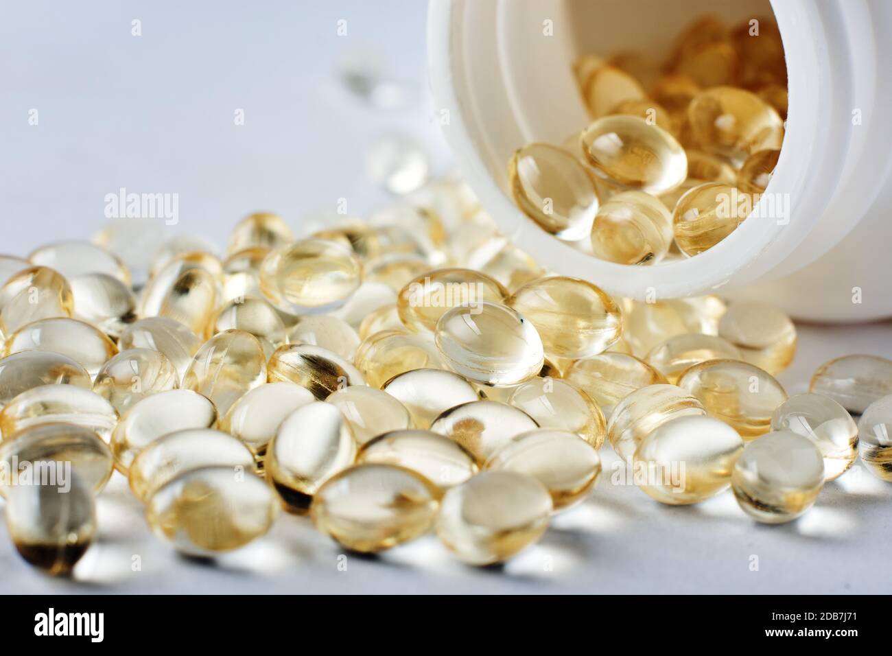 Capsules jaunes de vitamine D sur une surface grise. Banque D'Images
