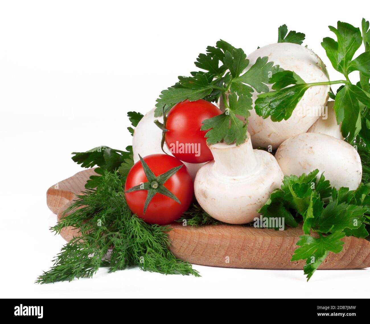 Tomates cerises, herbes et champignons sur le tableau noir de la cuisine Banque D'Images