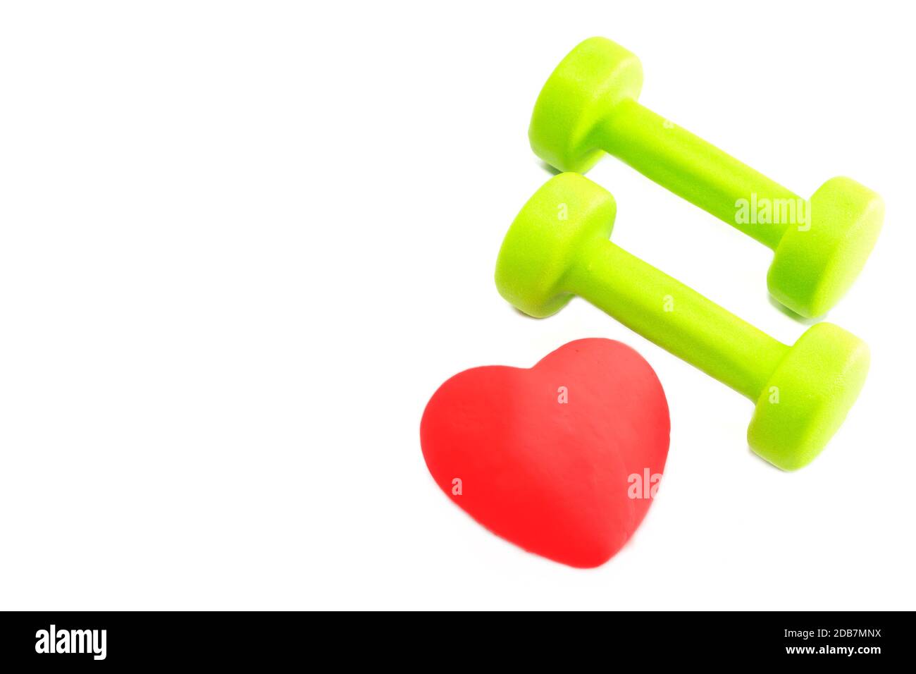 Haltères et cœur rouge sur fond blanc. Le concept d'un mode de vie sain. Banque D'Images