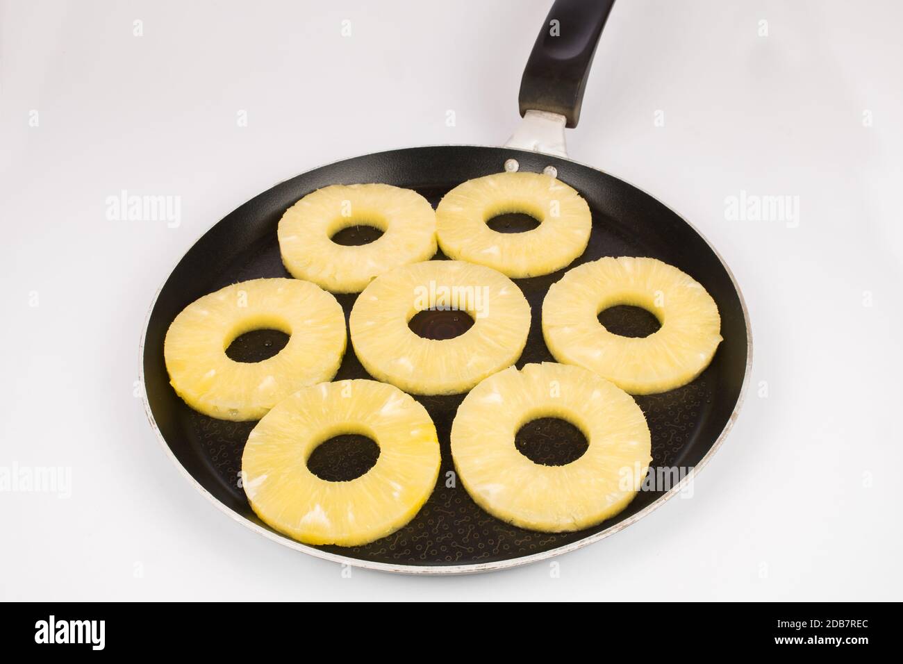 Pineaple dans une casserole préparée pour la torréfaction, sur fond blanc. Les ananas grillés sont vraiment délicieux hors-d'œuvre. Tranches de fruits. Dans une poêle. Banque D'Images