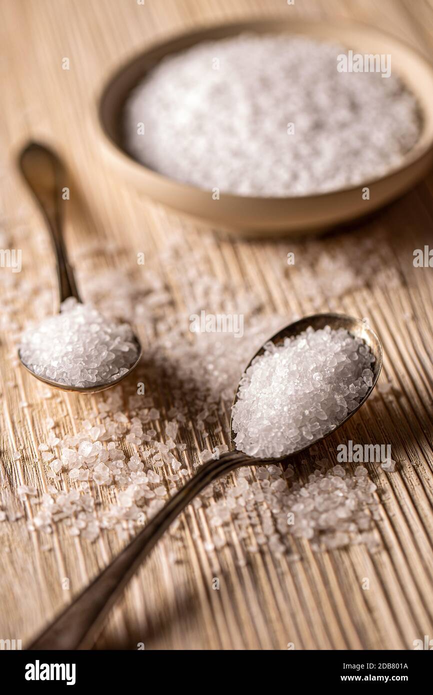 Sel de mer dans des cuillères anciennes sur fond de bois Banque D'Images