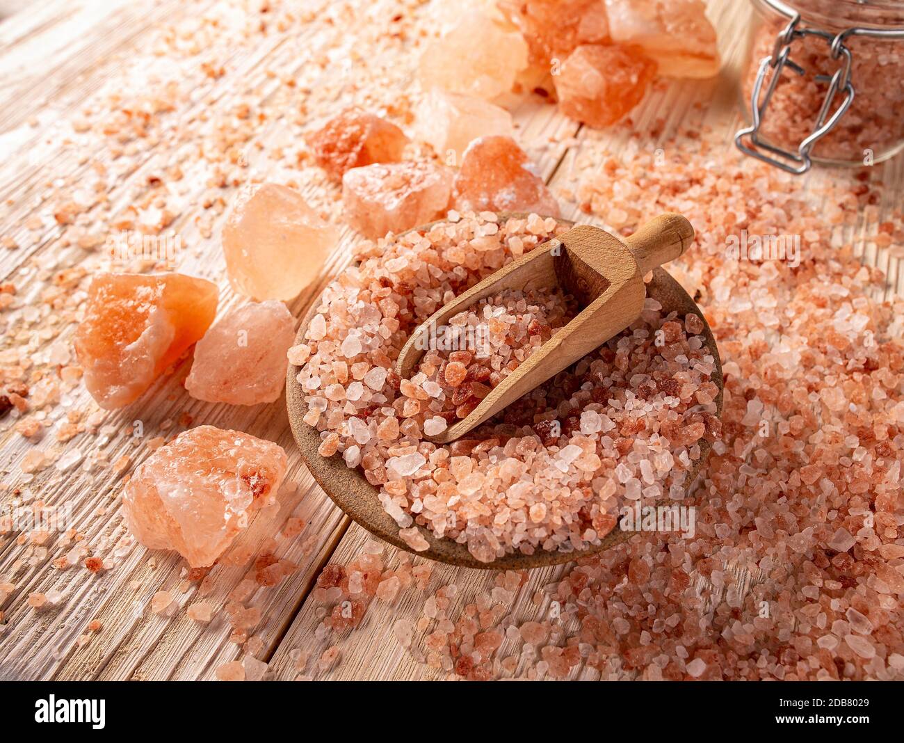 Composition de sel himalayen rose dans un bol avec pelle sur fond en bois Banque D'Images