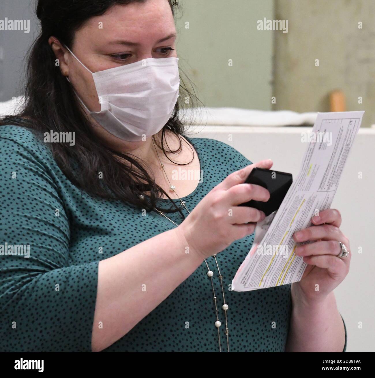 Racine, Wisconsin, États-Unis. 13 avril 2020. Les bulletins de vote déposés à racine, dans le Wisconsin, lors de la controverse présidentielle du 7 avril, les élections primaires et publiques du Wisconsin sont présentés en tableau le lundi 13 avril 2020. Le greffier de la Ville Tara Coolidge ouvre un bulletin de vote à chaque ouverture de l'enveloppe de bulletin de vote et vérifie le respect des lois électorales avant d'être introduit dans une machine à onglet. La ville n'avait que les options de vote par correspondance en voiture et absent; il n'y avait pas de vote en personne autorisé. L'élection a été tenue conformément aux directives des décisions des cours suprêmes du Wisconsin et des États-Unis. Les résultats devaient être anno Banque D'Images