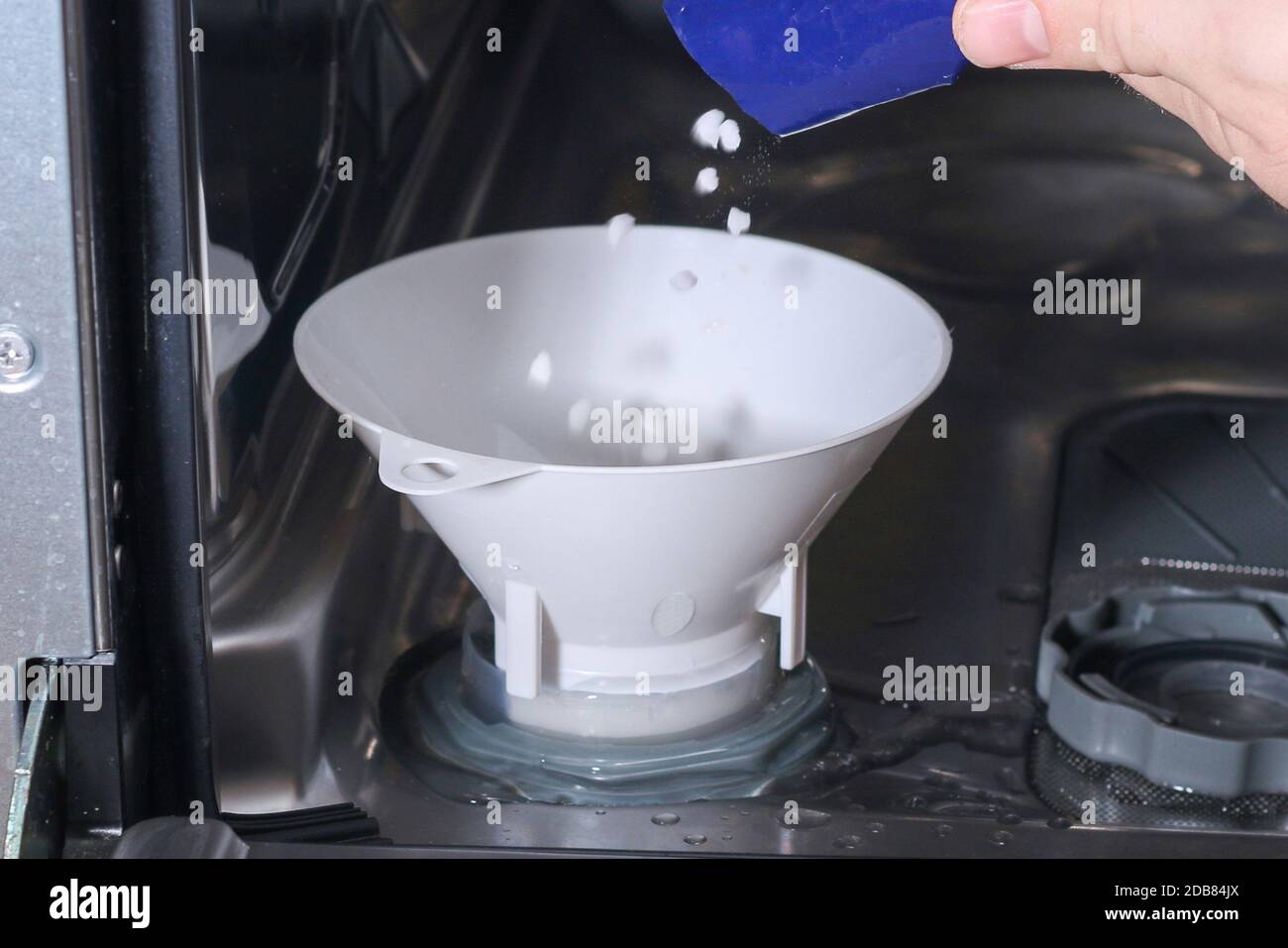 Man ouvre le réservoir de sel au lave-vaisselle et y remplit un sel spécial  Photo Stock - Alamy