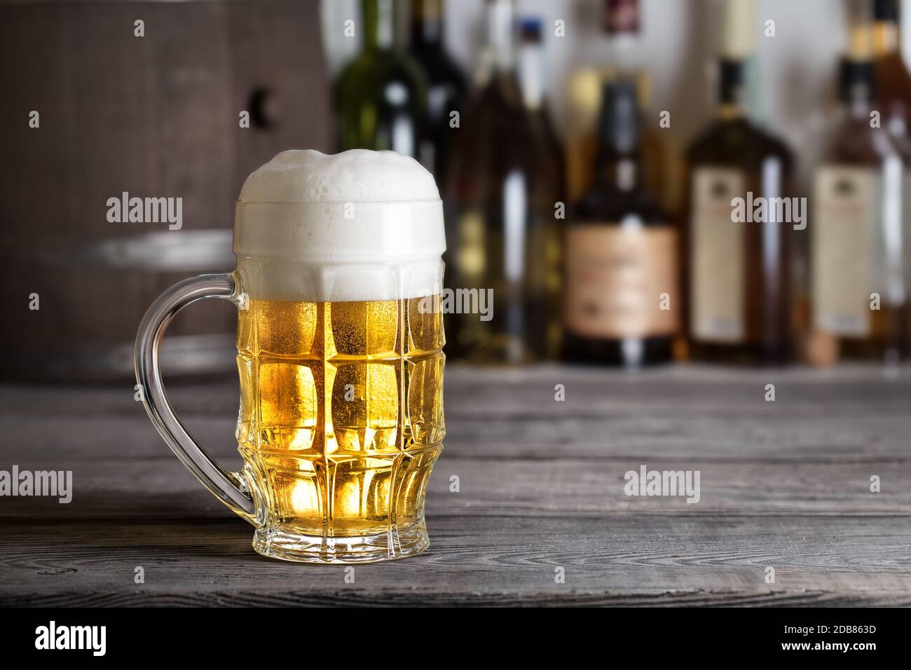 Grand verre de bière légère avec de la mousse sur comptoir bar contre  l'arrière-plan de batterie Photo Stock - Alamy