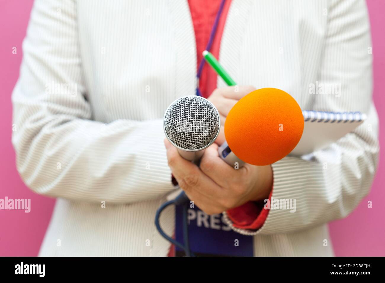 Reporter à la conférence de presse, la rédaction de notes, holding microphone Banque D'Images