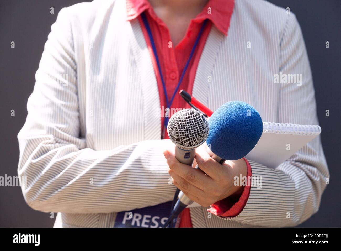 Journaliste à la conférence de presse, la rédaction de notes, holding microphone Banque D'Images