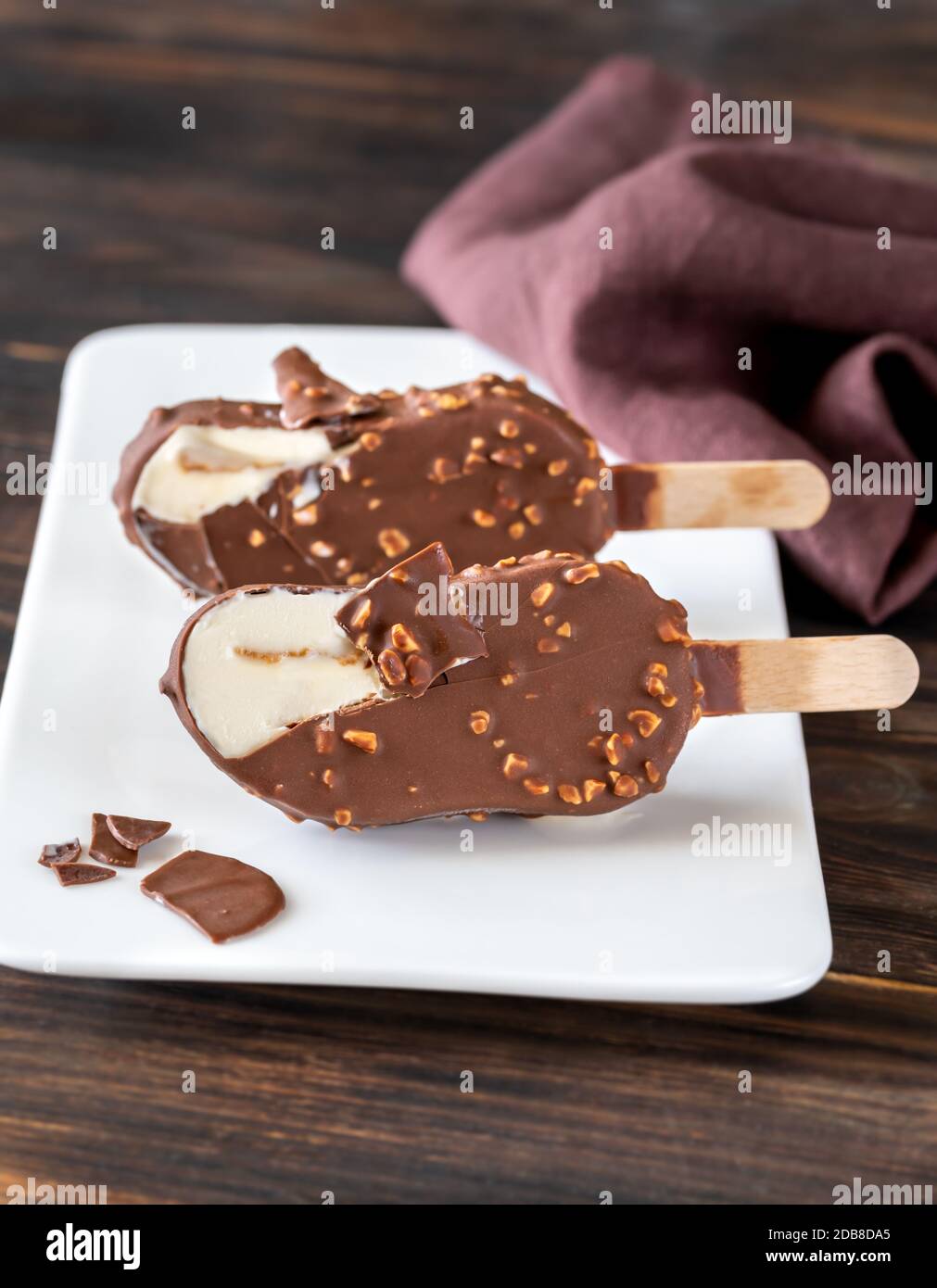 Bar à glace à la vanille recouvert de chocolat sur la plaque blanche Banque D'Images