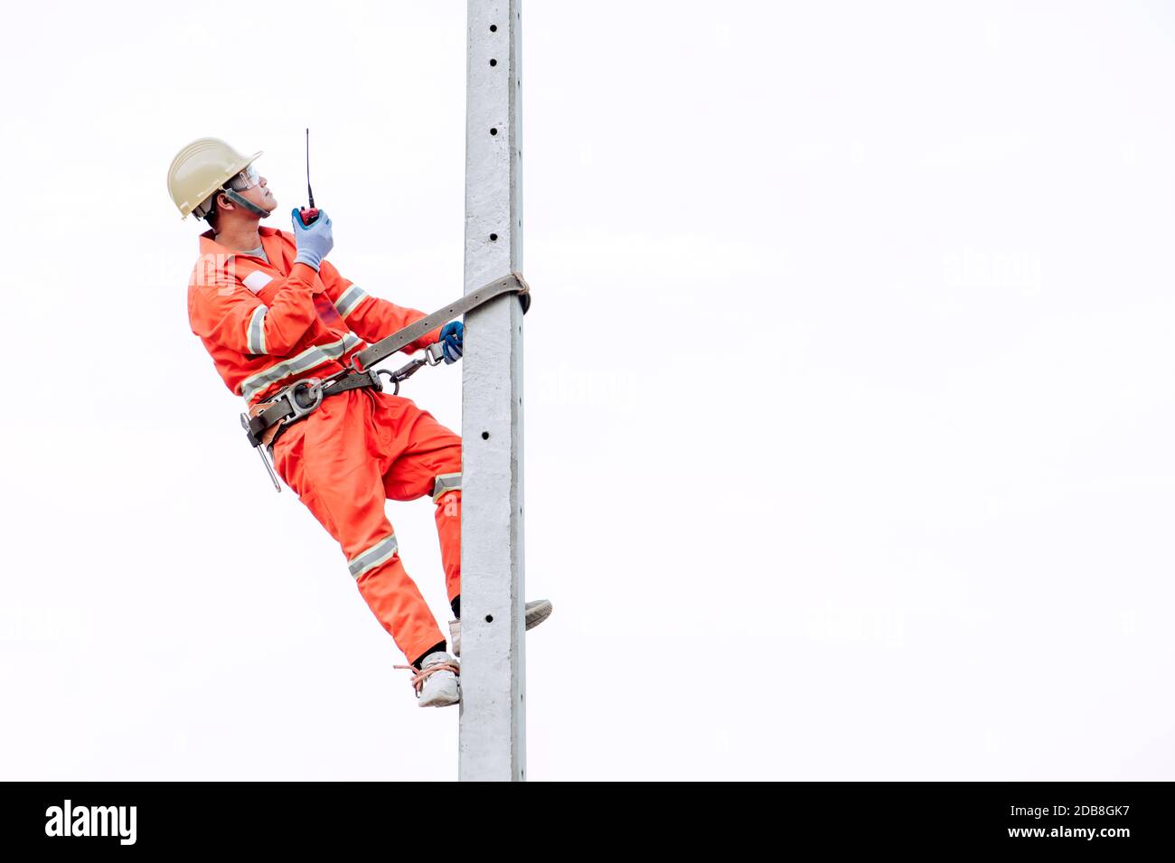 Ouvrier de construction escalade un poteau métallique, Thaïlande Banque D'Images
