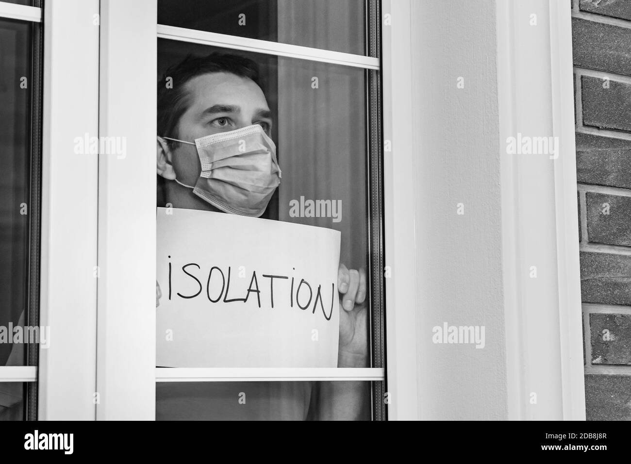 L'homme dans un masque médical tient un comprimé - isolement. Isolement à la maison pour l'auto-quarantaine. Mise en quarantaine à domicile, auto-isolement en raison du coronavirus di Banque D'Images