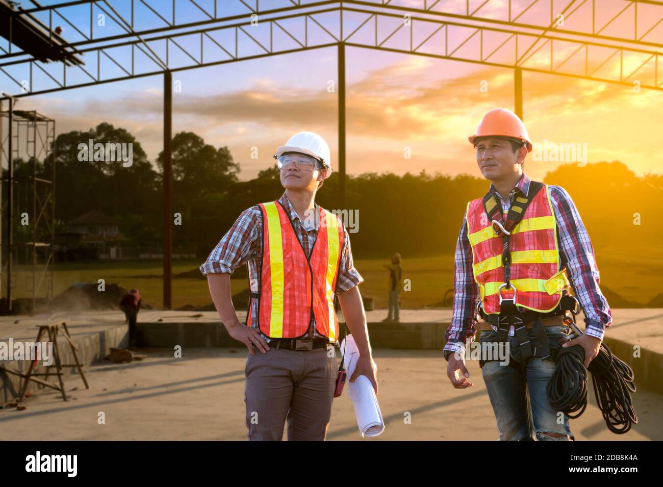 Deux ingénieurs qui étudient les plans de construction d'un chantier de construction, en Thaïlande Banque D'Images