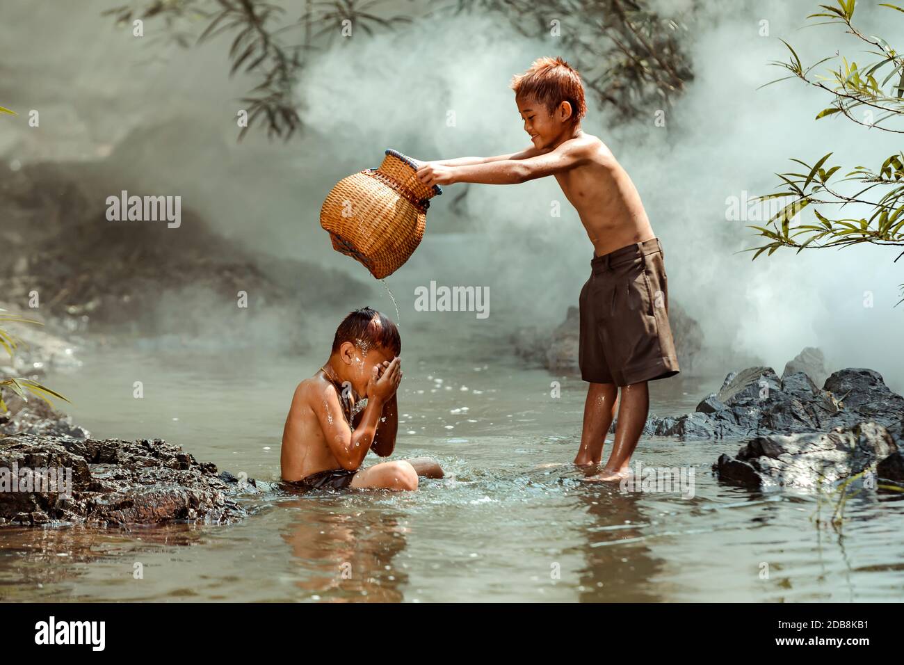 Deux garçons se lavant dans une rivière, en Thaïlande Banque D'Images