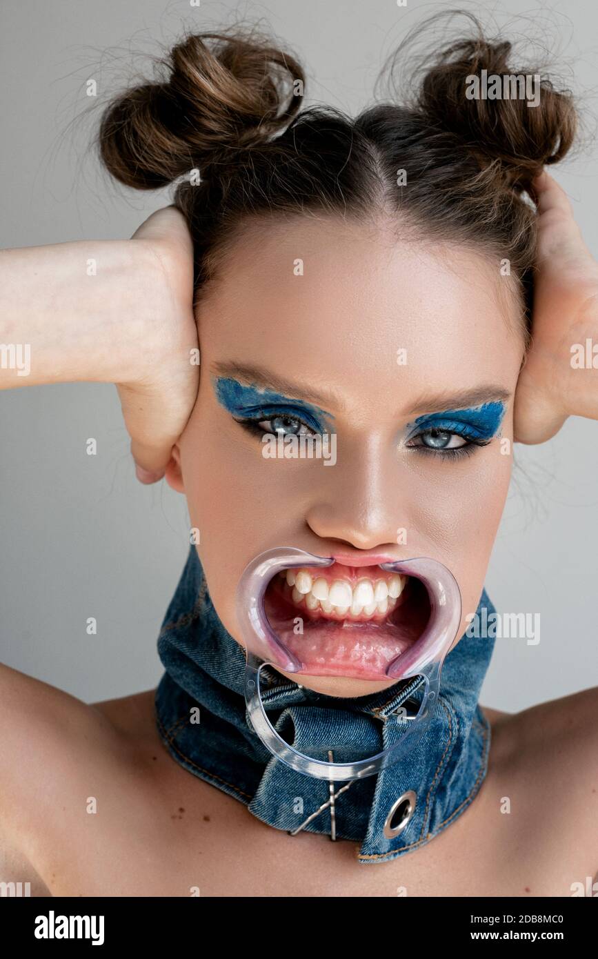 Portrait d'une femme portant un revêtement d'enrouleur pour bouche dentaire ses oreilles Banque D'Images Portrait d'une femme portant un revêtement d'enrouleur pour bouche dentaire ses oreilles Banque D'Images