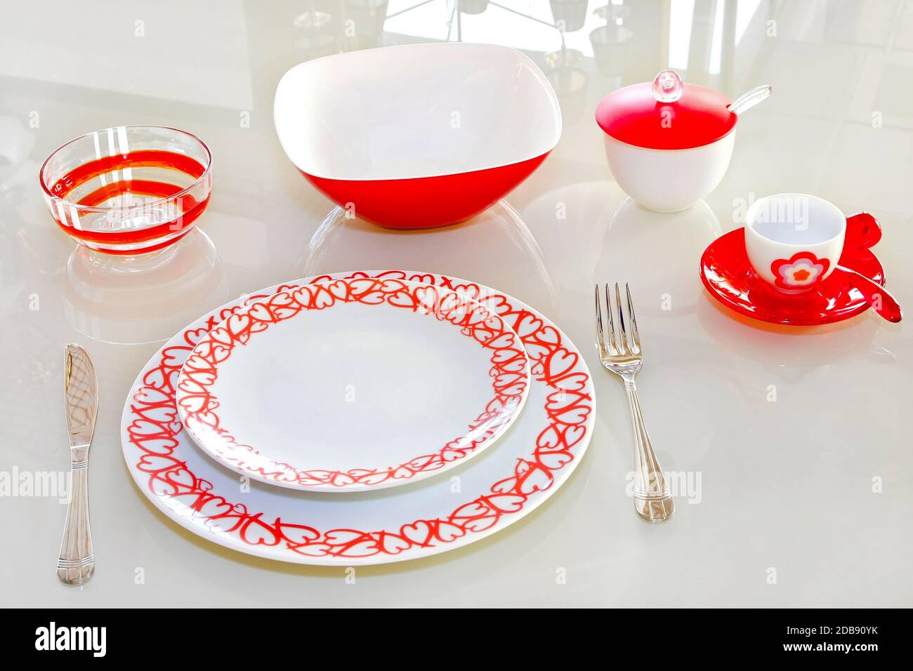 J'adore la vaisselle avec des coeurs rouges à la table en verre Photo Stock  - Alamy