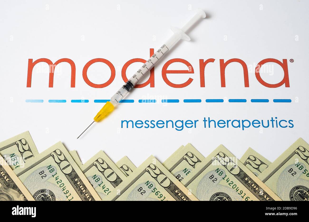 Stone / Royaume-Uni - novembre 16 2020: Logo de la société médicale Moderna vu sur la brochure avec la seringue et les dollars. Moderna Inc produit de l'ARNm- Banque D'Images