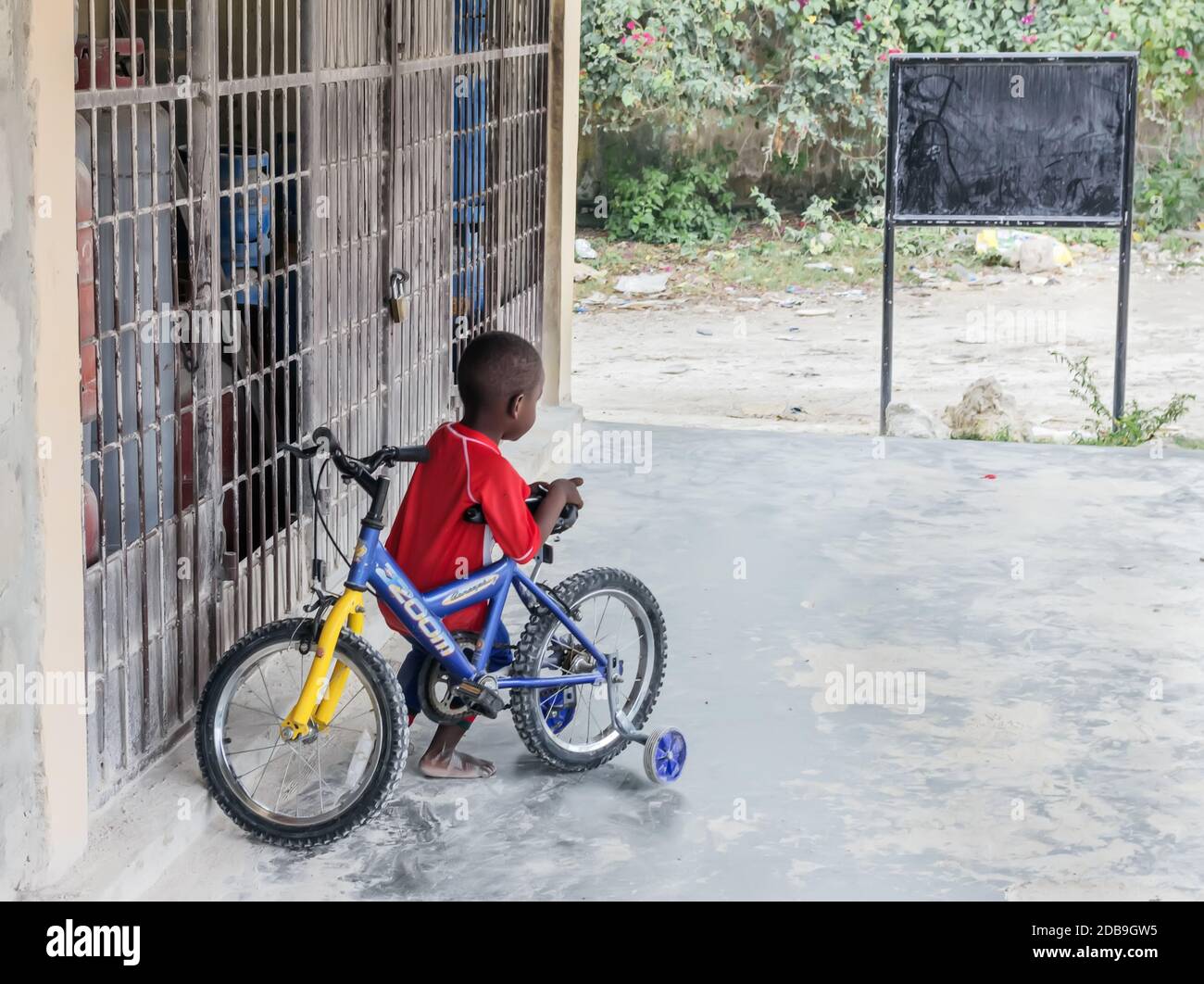 Nungwi, Zanzibar, le 18 mars 2020 : joli garçon à la peau sombre avec vélo le jour Banque D'Images