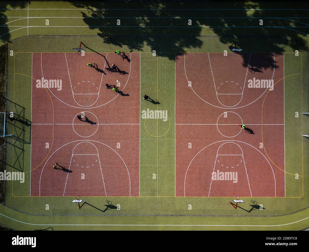 Vue aérienne d'un terrain de football avec des gens jouer au soccer sur elle - dans le chaud soleil matinal, jetant de longues ombres Banque D'Images