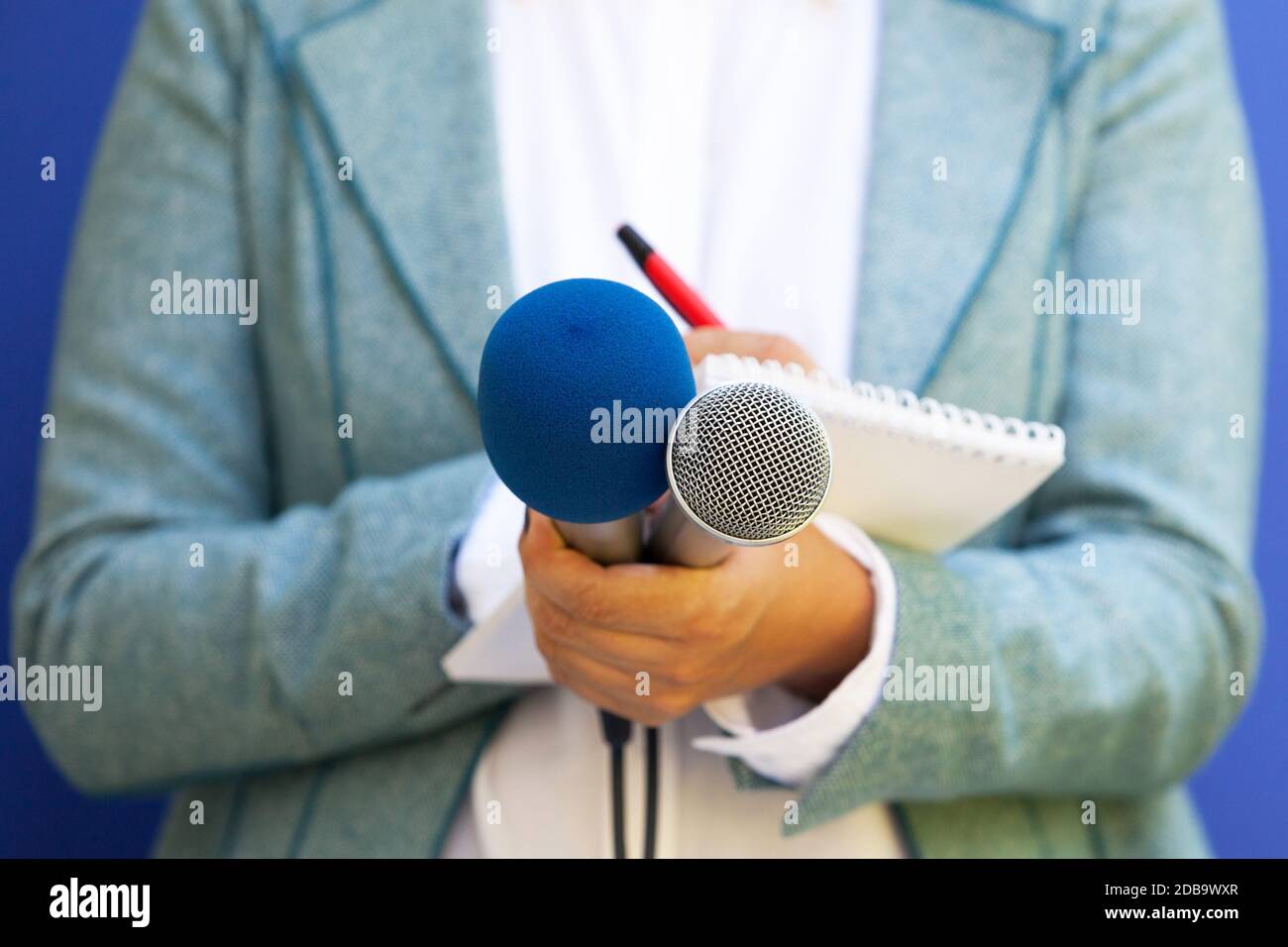 Journaliste à la conférence de presse, la rédaction de notes, holding microphone Banque D'Images
