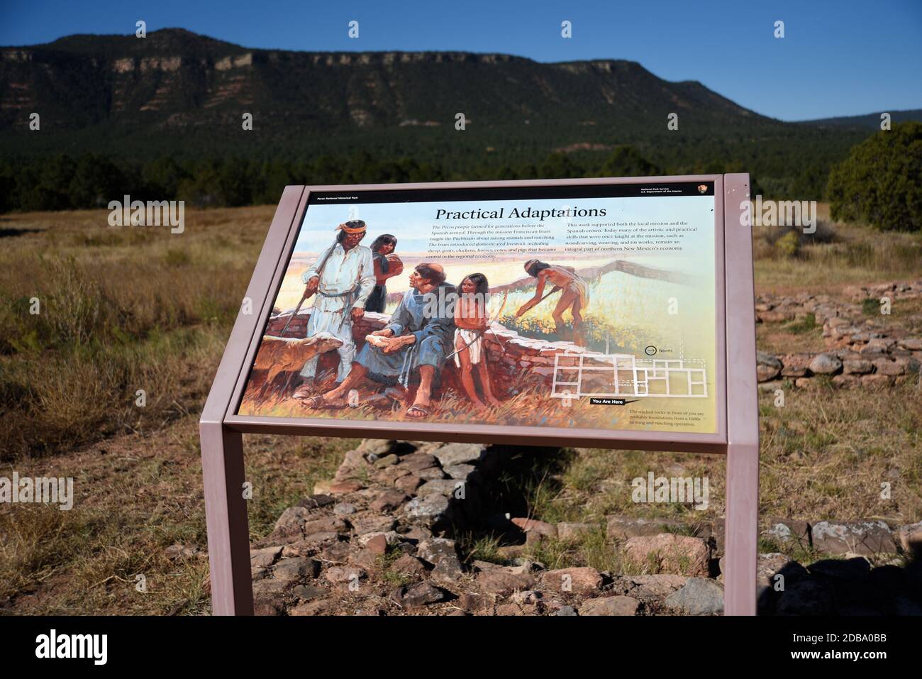 Un panneau d'instruction illustre la vie quotidienne du XVIIe siècle, tandis que les Indiens d'Amérique espagnols et autochtones se mélangent au parc historique national Pecos, à Pecos, AU NOUVEAU-MEXIQUE. Banque D'Images