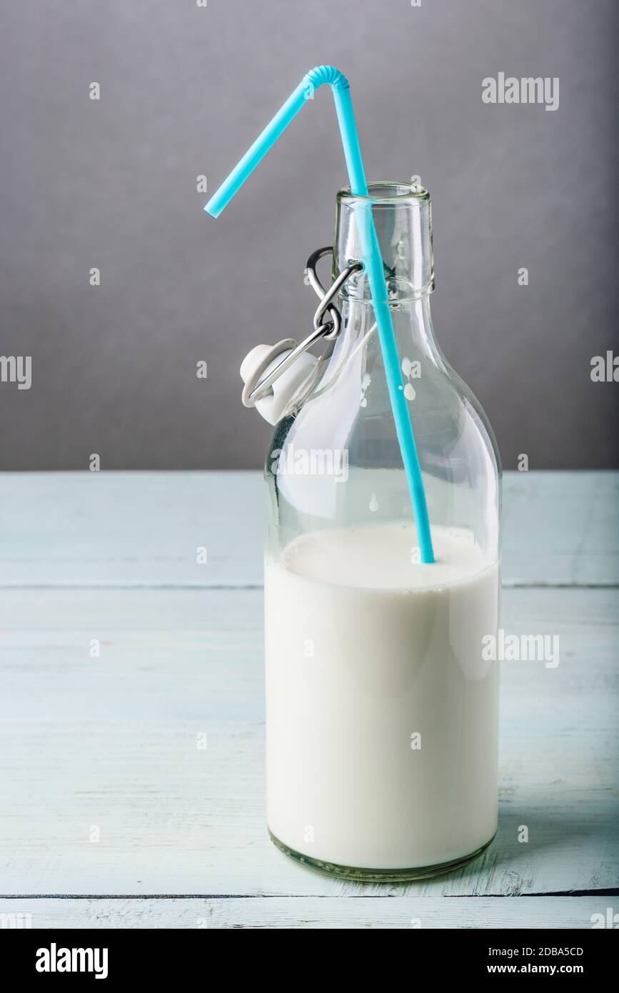 Bouteille de lait en verre avec paille bleu Banque D'Images