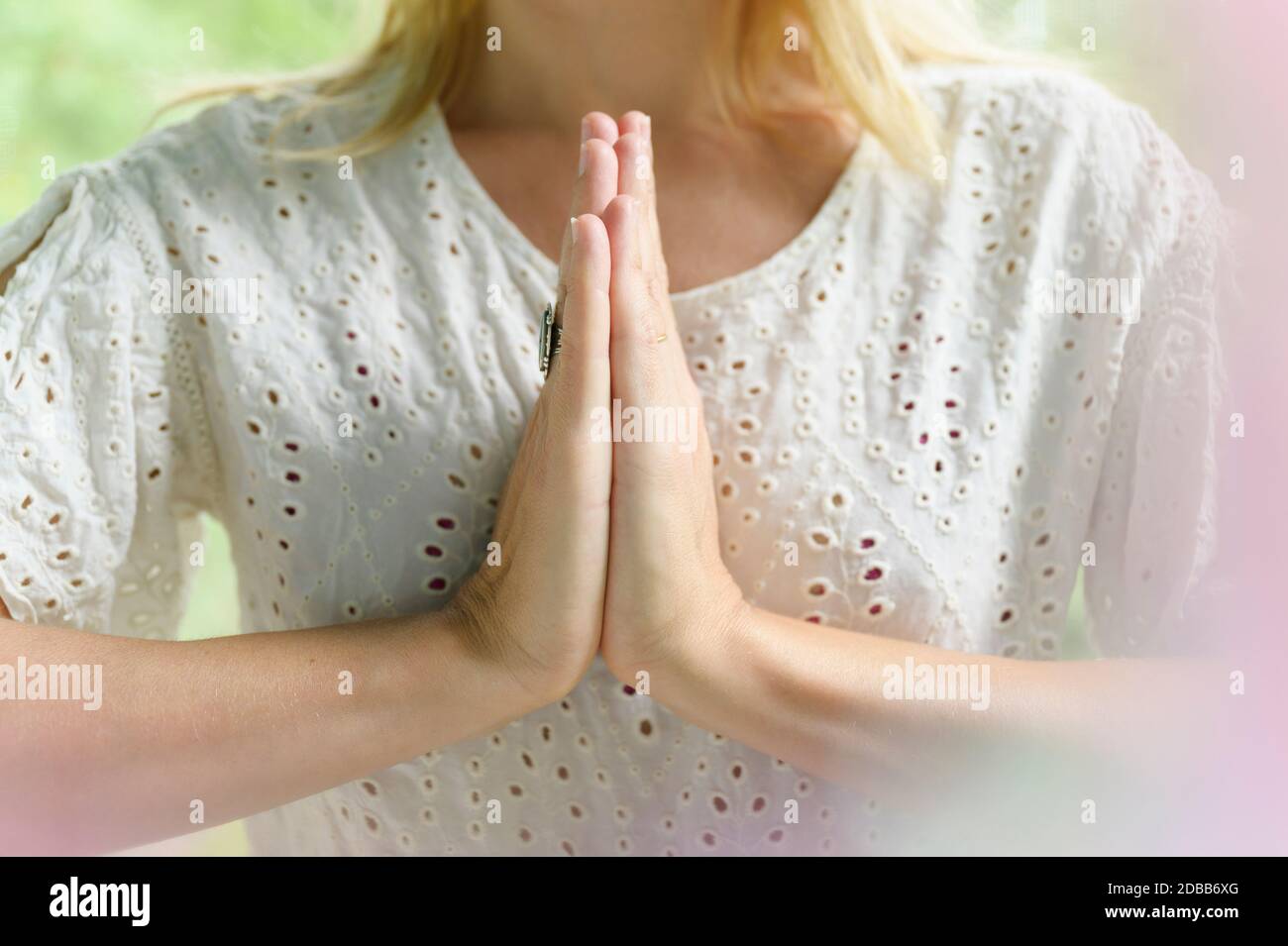 Gros plan d'une femme blonde faisant du yoga avec les mains jointes Banque D'Images