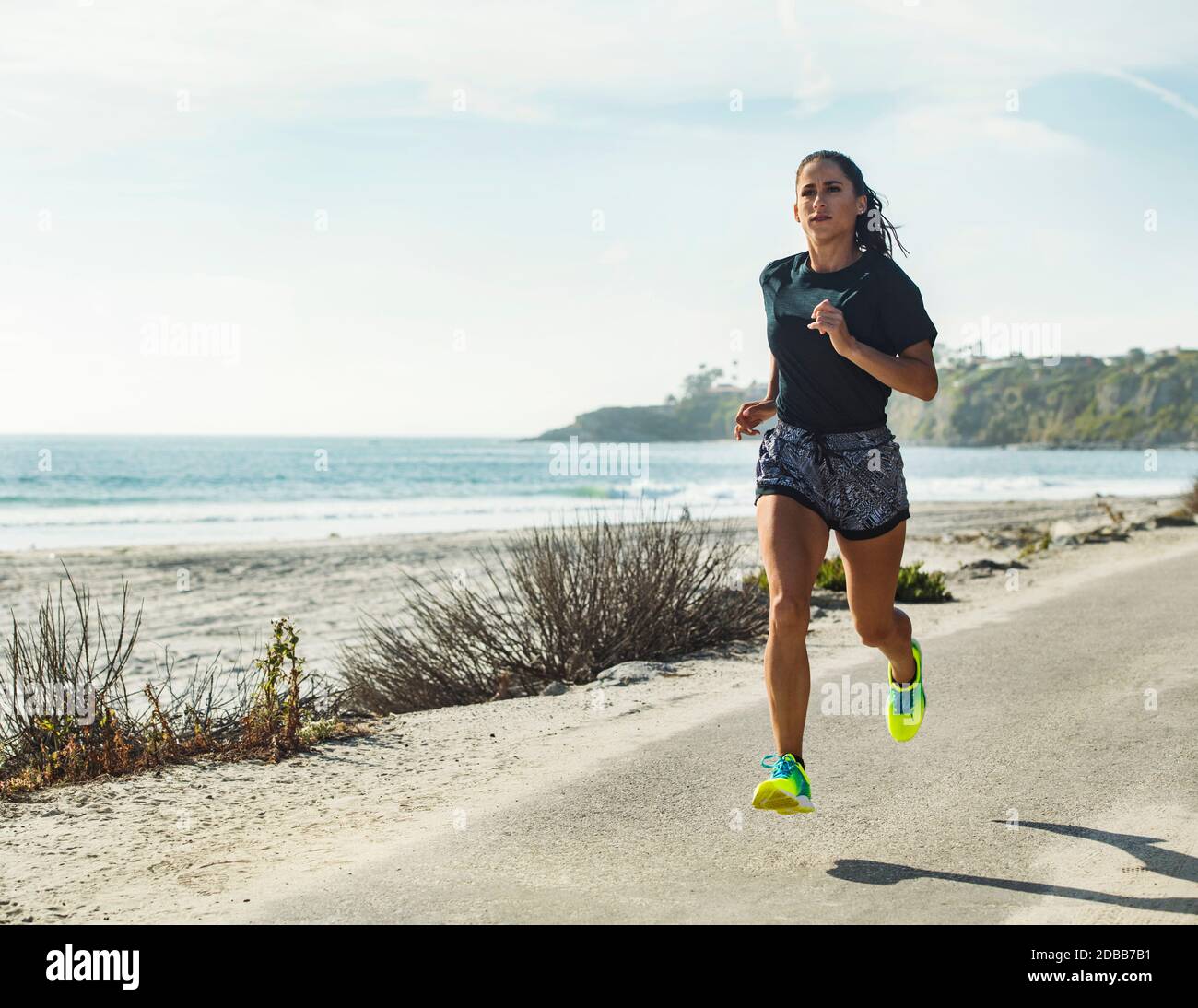 États-Unis, Californie, Dana point, femme en train de courir sur la route le long de la côte Banque D'Images