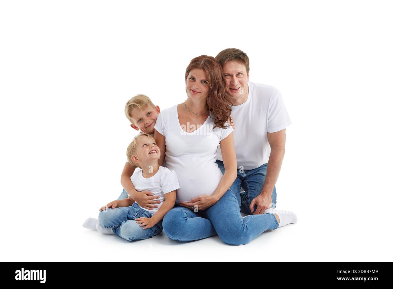 Famille sympathique. Une jeune femme enceinte avec deux enfants et son mari  sont assis, isolés sur un fond blanc. Parents heureux. Mère enceinte a  Photo Stock - Alamy