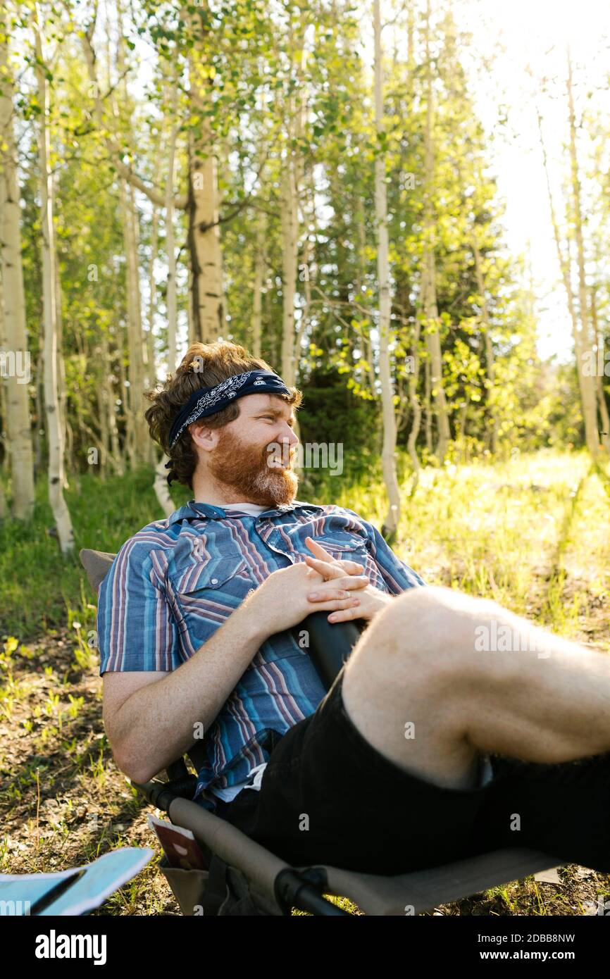 États-Unis, Utah, Parc national d'Uinta, Homme relaxant en campant dans la forêt Banque D'Images