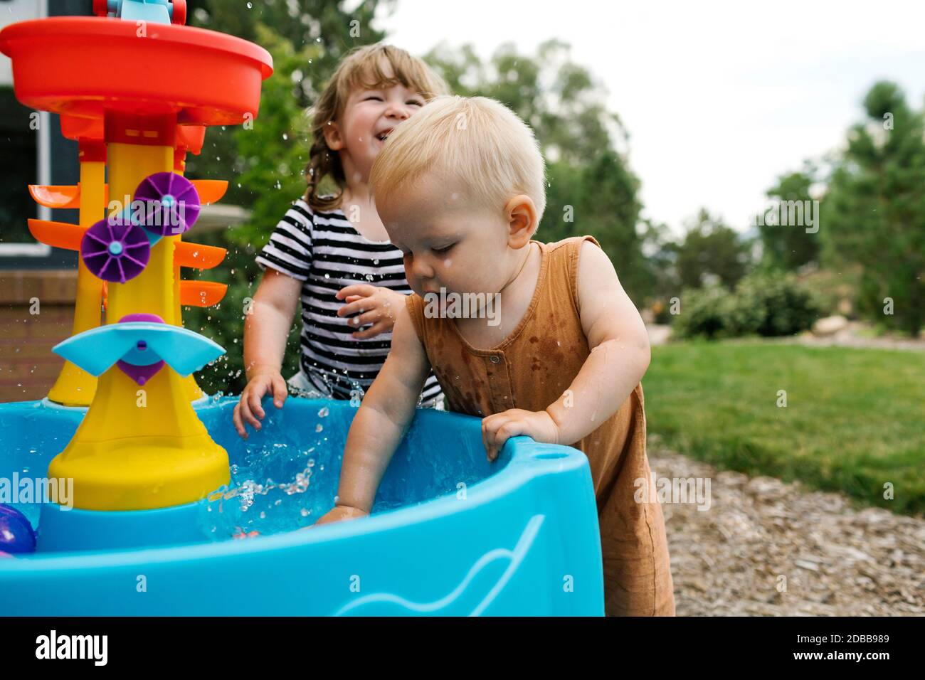 Petite fille (2-3) et bébé garçon (18-23 mois) jouer dans le jardin Banque D'Images